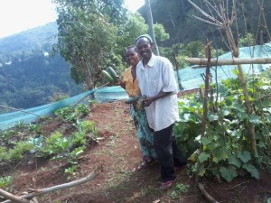 Mama and Baba BMM smiling over a good harvest of zucchini and cucumbers.
